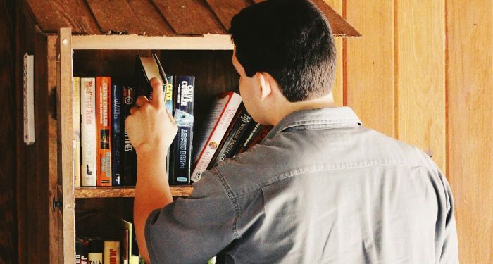 a-light-medium-skinned-man-looking-at-books-in-a-Little-Free-Library.jpg.optimal.jpg